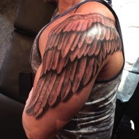 Simple designed and painted black and white wing shoulder tattoo