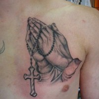 Einfache große schwarzweiße betende Hände mit Kreuz Tattoo an der Brust