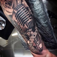 Simple designed black and white microphone with music notes tattoo on arm