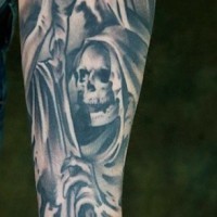 Tatuaje en el antebrazo, esqueleto malo sonriente en capa oscura