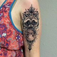 Simple homemade black ink raccoon tattoo on shoulder stylized with geometrical ornamnets