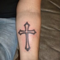 Einfaches hausgemachtes schwarzweißes Kreuz Tattoo am Unterarm
