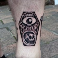 Simple little black and white coffin with skull and eye tattoo on leg