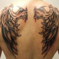 Simple little black ink monster wings tattoo on upper back