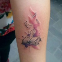 Tatuaje en el antebrazo, libro diminuto con paginas viejas