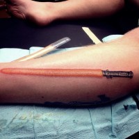 Einfaches kleines rotes farbiges detailliertes Bein Tattoo vom Sith Lichtschwert