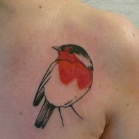 Simple little tiny colored bird tattoo on shoulder