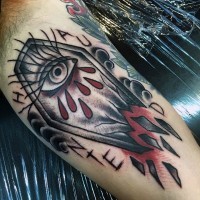 Simple multicolored bleeding coffin with letting and eye tattoo on arm