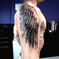 Simple painted black and white wing tattoo on shoulder zone