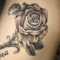 Einfache gemalt detaillierte schwarzweiße Rose mit Schriftzug Tattoo am Arm