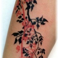 Tatuaje en el antebrazo, ramitas de ábroles de colores negro y rojo