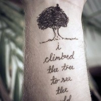 Simple romantic style black ink tree with lettering tattoo on wrist