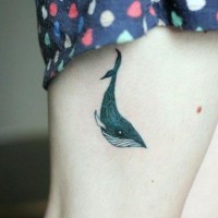 Simple tiny black ink wale tattoo on thigh