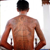 Sitzender Buddha und buddhistische Symbole Tattoo am Rücken