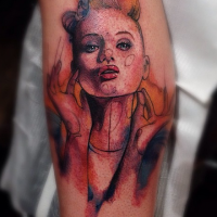 Sketch style colored funny woman face tattoo on leg