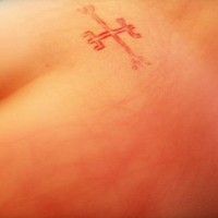 Tatuaje sacrificio en la piel símbolo de la cruz