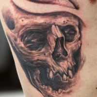 Tatuaje en el costado, cráneo viejo con un par de dientes