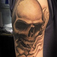 Realistic human skull tattoo on arm