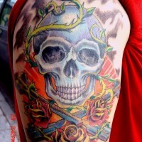 Tatuaggio colorato sul deltoide il teschio & le rose & le spade