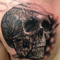Tatuaje en el pecho,  cráneo con silueta de árbol y 
instrumentos medicos