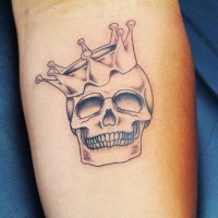Skull with crown tattoo on forearm