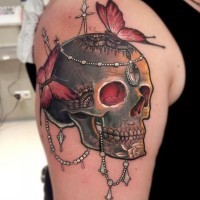 Skull with jewelery and red butterflies tattoo on shoulder