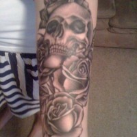 Skull with roses tattoo on forearm