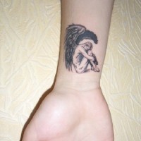 Small angel tattoo on wrist