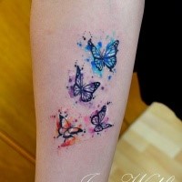 Kleines schön aussehendes farbiges Unterarm Tattoo mit fliegenden Schmetterlingen