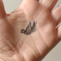 Small bird tattoo with pattern on palm