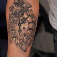 Small black and white forearm tattoo of old clock