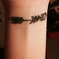 Small black arrow tattoo on girls wrist