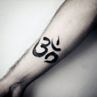 Small black ink forearm tattoo of Hinduism symbol