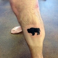 Small black ink leg tattoo of black bull