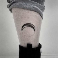 Small black ink leg tattoo of moon
