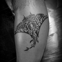 Small black ink ray tattoo on leg stylized with tribal ornaments