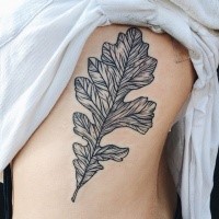 Small black ink side tattoo of typical leaf