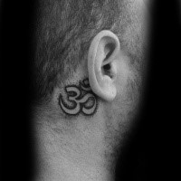 Small black ink symbol tattoo behind ear