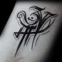 Small black ink symbol tattoo on arm