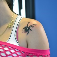 Small black spider tattoo on shoulder for girls