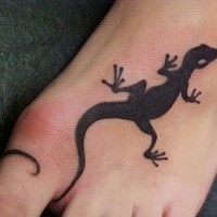Small blackwork style foot tattoo of small lizard