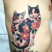 Small cartoon style colored side tattoo of cats with flowers