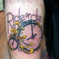 Small cartoon style thigh tattoo of vintage bicycle and lettering