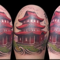 Small cute looking red temple tattoo on shoulder with lettering