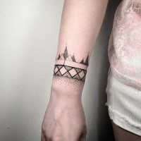 Small dotwork style black ink wrist tattoo of geometrical ornaments