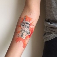 Small illustrative style forearm tattoo of Lego storm trooper
