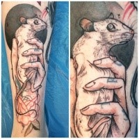 Small illustrative style leg tattoo of hand holding rat