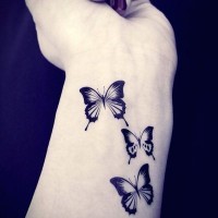 Tatuaje en la muñeca, tres mariposas estupendas negras