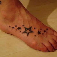 piccoli stelline nere tatuaggio su piede di ragazza