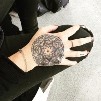 Small stippling style hand tattoo of flower